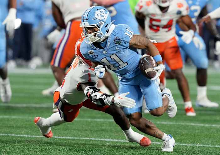 Dec 3, 2022; Charlotte, North Carolina, USA; North Carolina Tar Heels wide receiver Josh Downs (11) runs past Clemson Tigers safety Andrew Mukuba (1) during the first quarter of the ACC Championship game at Bank of America Stadium. Mandatory Credit: Jim Dedmon-USA TODAY Sports